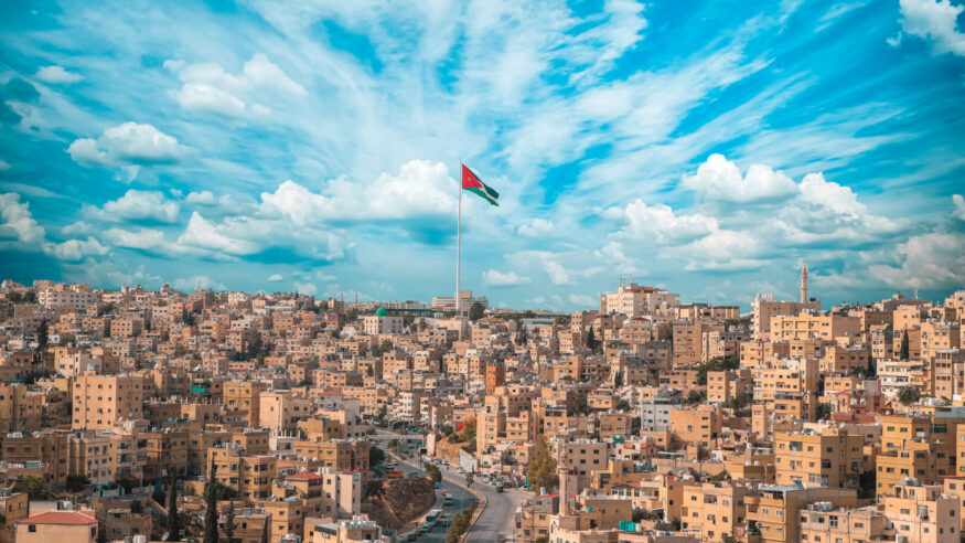Jordan flag in Amman, landscape view of cloudy sky background
