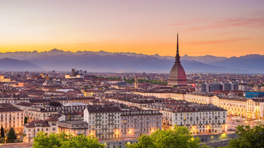Cityscape of Torino (Turin, Italy) at dusk with colorful moody sky. The Mole Antonelliana towering on the illuminated city below.